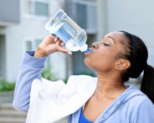 Woman drinking water in exercise clothes